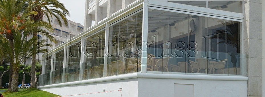 Instalación de cerramiento de terraza con cortinas de cristal sin guía al suelo en el Gran Hotel Las Fuentes de Alcossebre en la provincia de Castellón.