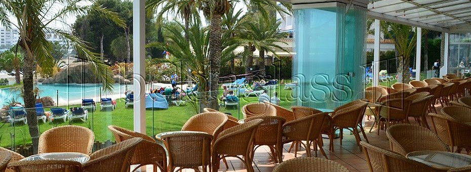 Instalación de cerramiento de terraza con cortinas de cristal sin guía al suelo en el Gran Hotel Las Fuentes de Alcossebre en la provincia de Castellón.