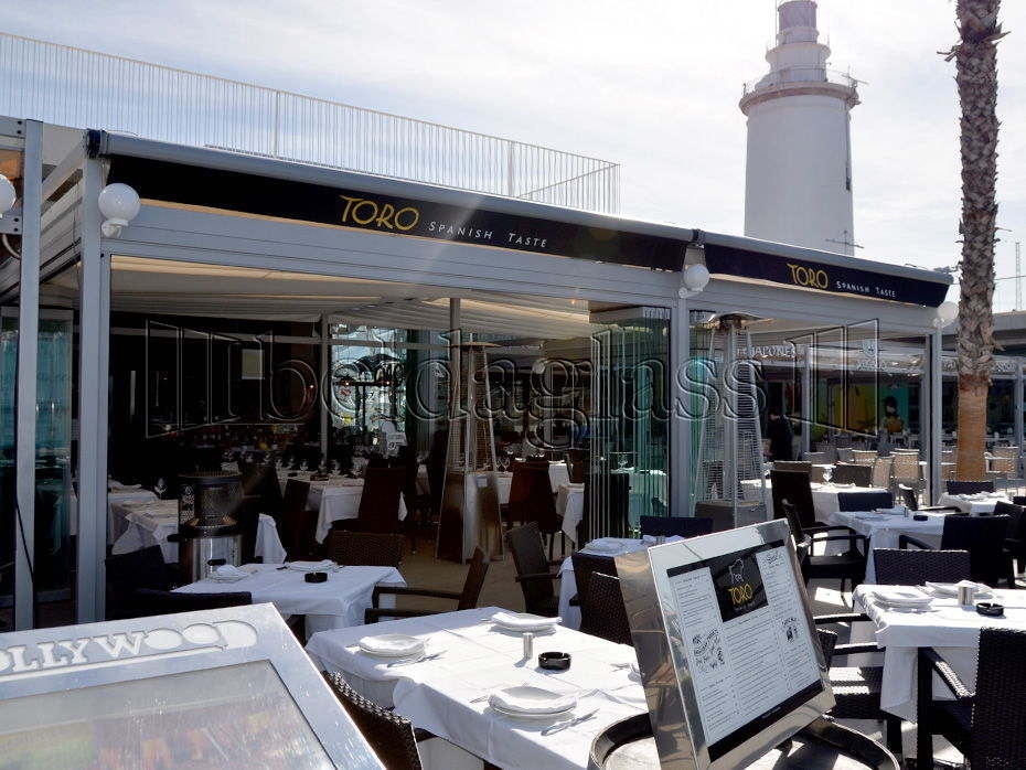 Cerramiento de terraza para hostelería a pie de puerto en Málaga, donde las normativas obligan a la instalación de un sistema sin guías al suelo Beldaglass
