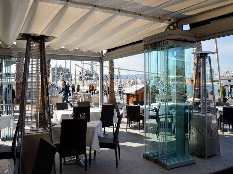 Cerramiento de terraza para hostelería a pie de puerto en Málaga, donde las normativas obligan a la instalación de un sistema sin guías al suelo Beldaglass