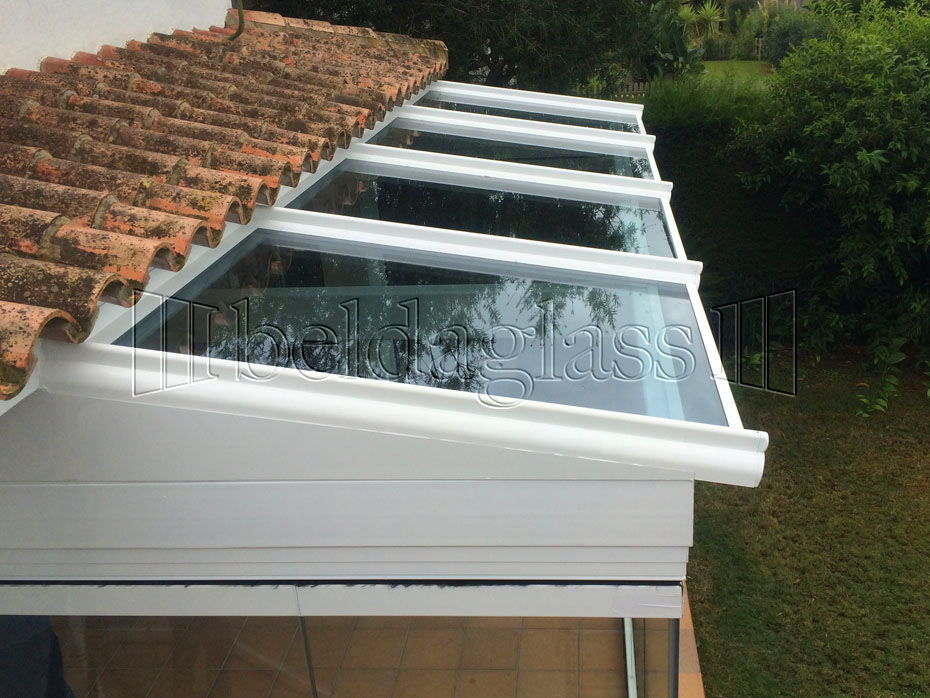 Proyecto de instalación de un porche acristalado en una vivienda en Rota, Cádiz, con techo de cristal y cortinas de cristal sin guía al suelo. ¡Llámanos!
